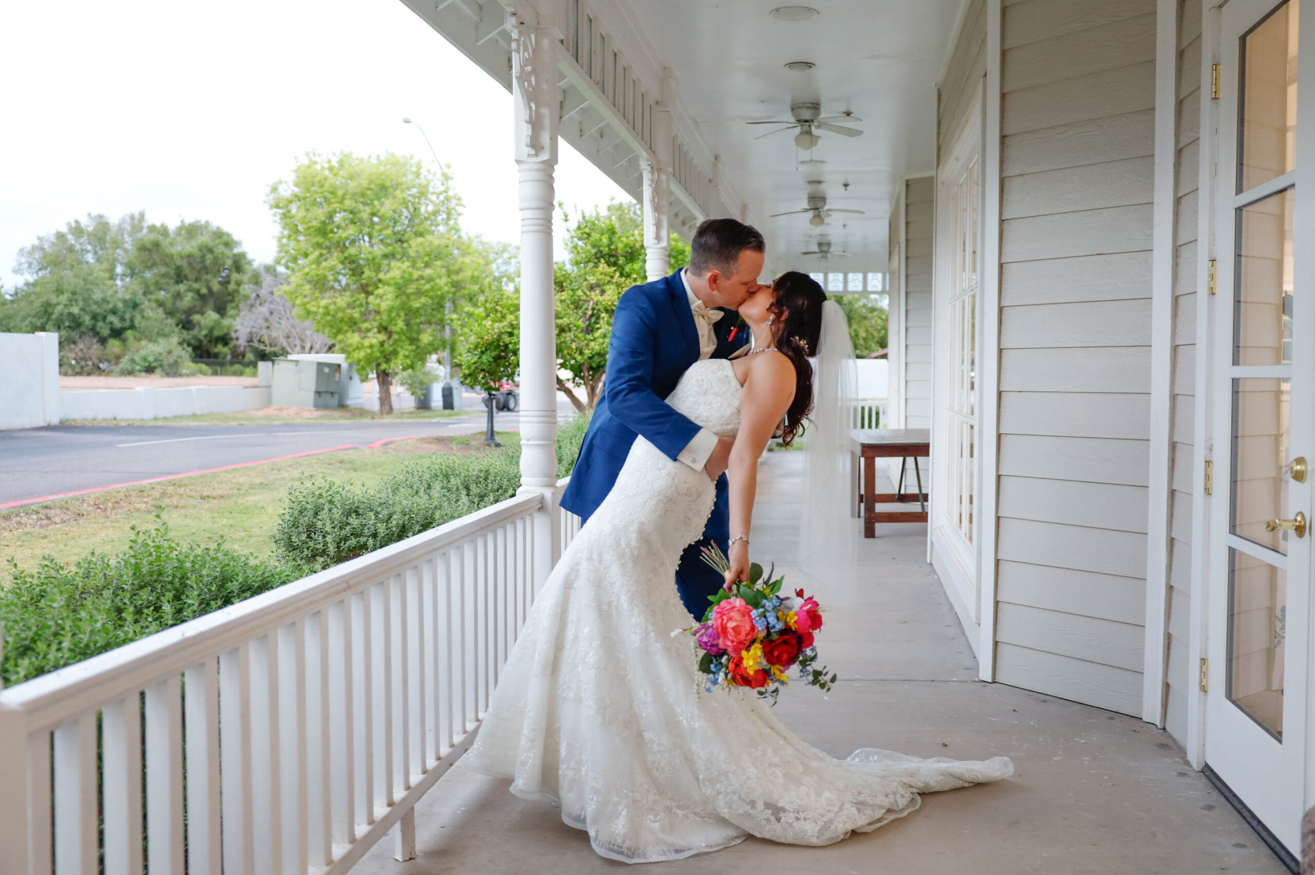 Bride and groom kissing on a porch