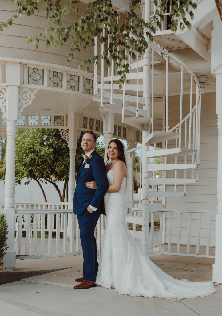 Wedding couple taking wedding portrait pictures in front a beautiful white staircase.