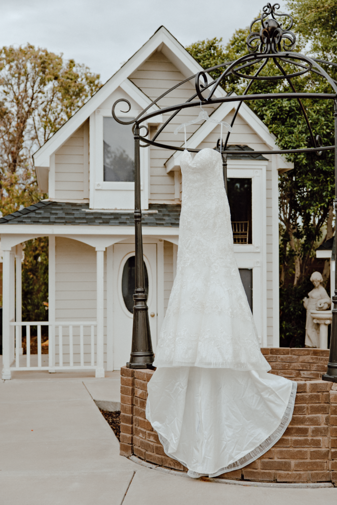 brides white lace wedding dress hanging outside for details photos before she puts it on.