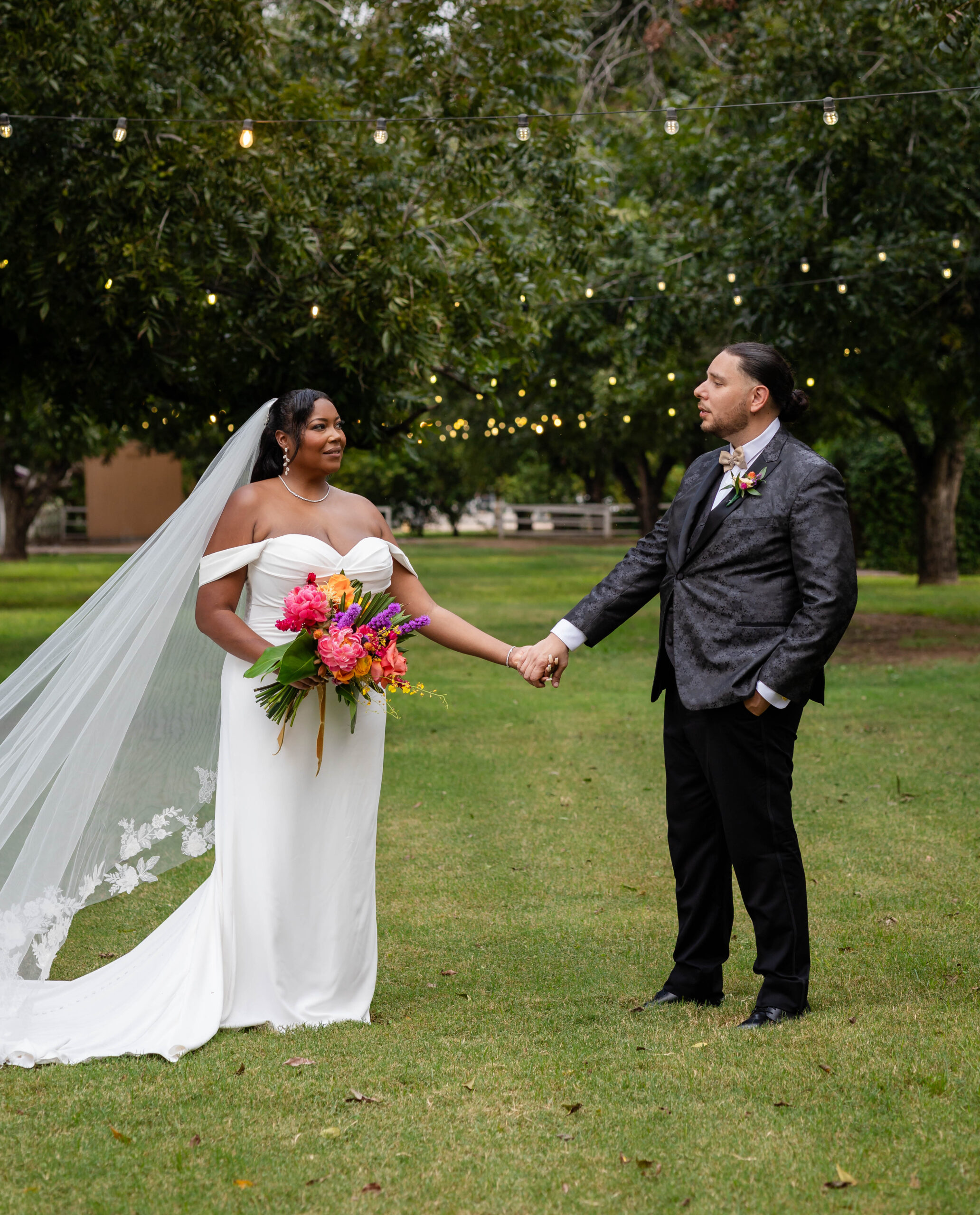bride and groom holding hands while looking at each other