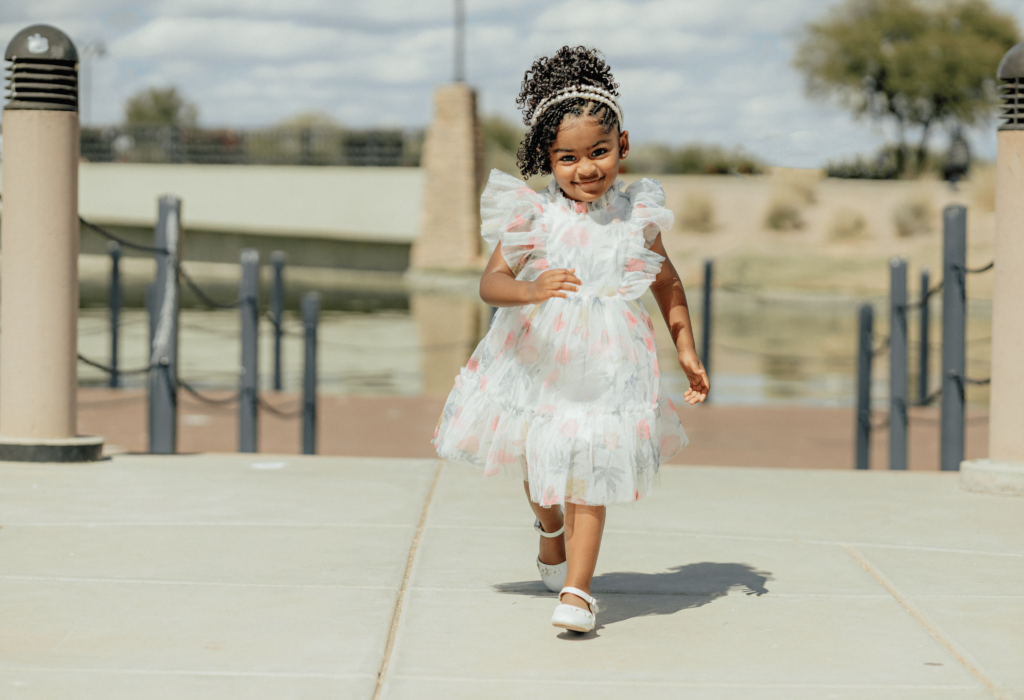 a little girl running towards the camera and her pretty dress. 