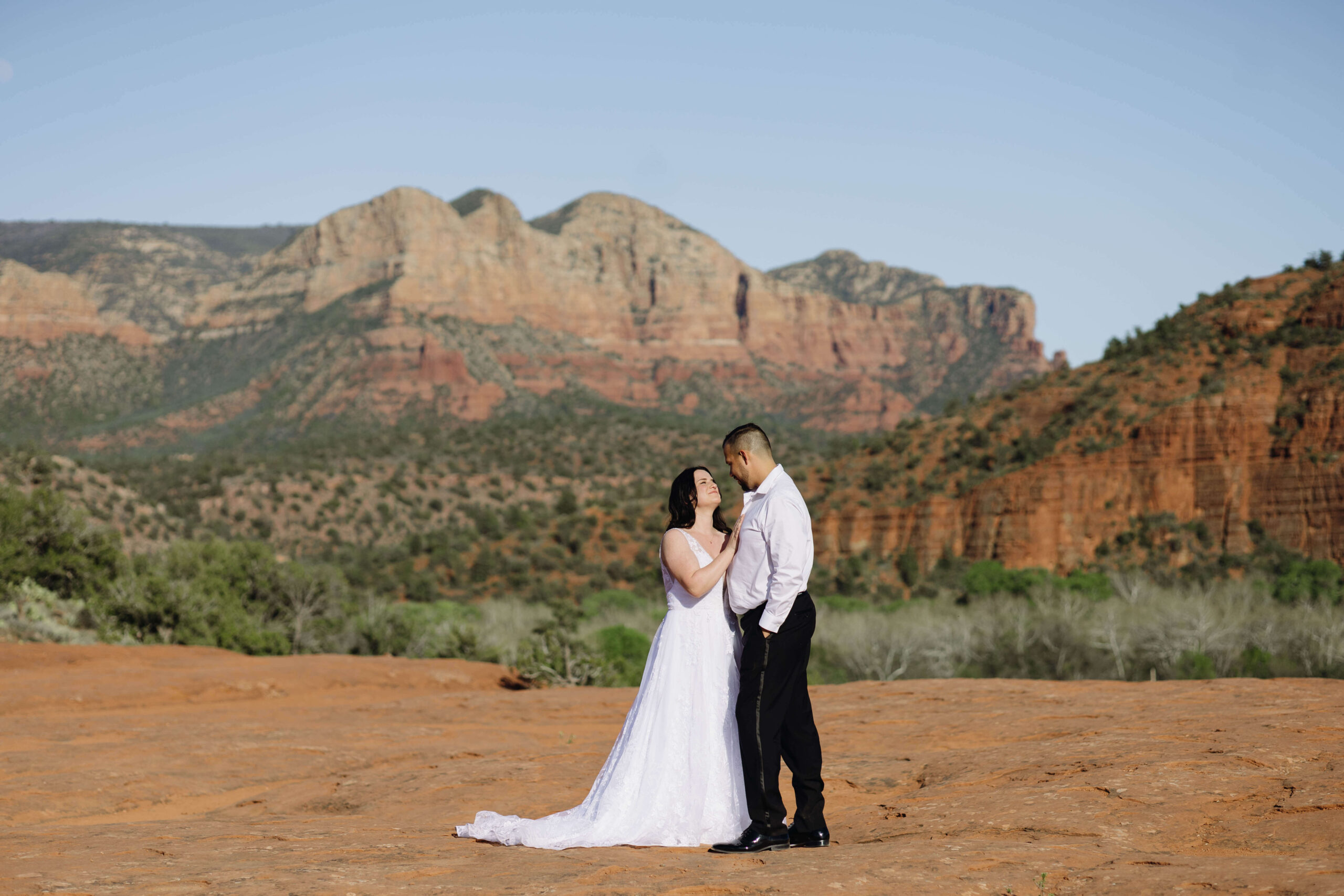 bride and groom in Sedona taking wedding photos while looking at the red rocks