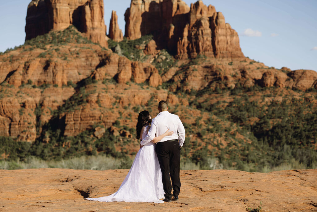 bride and groom facing the Sedona

 red rock mountain for their first look