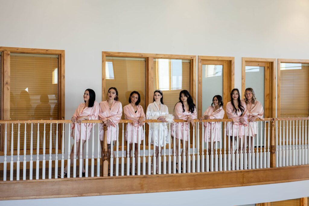 Bride and bridesmaids taking photos on a balcony in Phoenix AZ