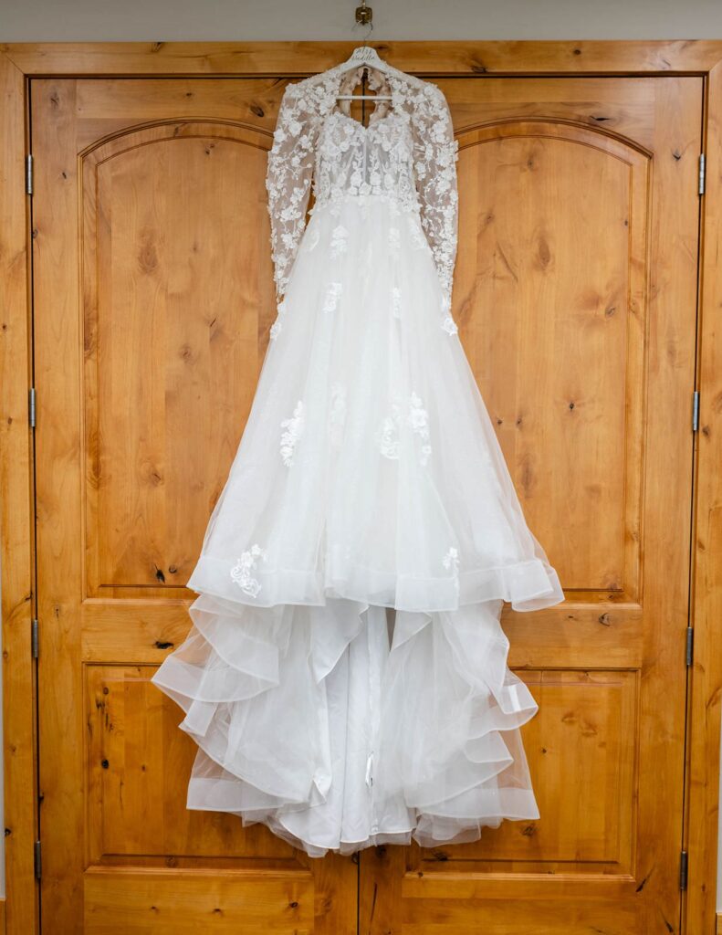 Bride wedding dress hanging on a wooden door at The 55th Place wedding venue in Mesa AZ