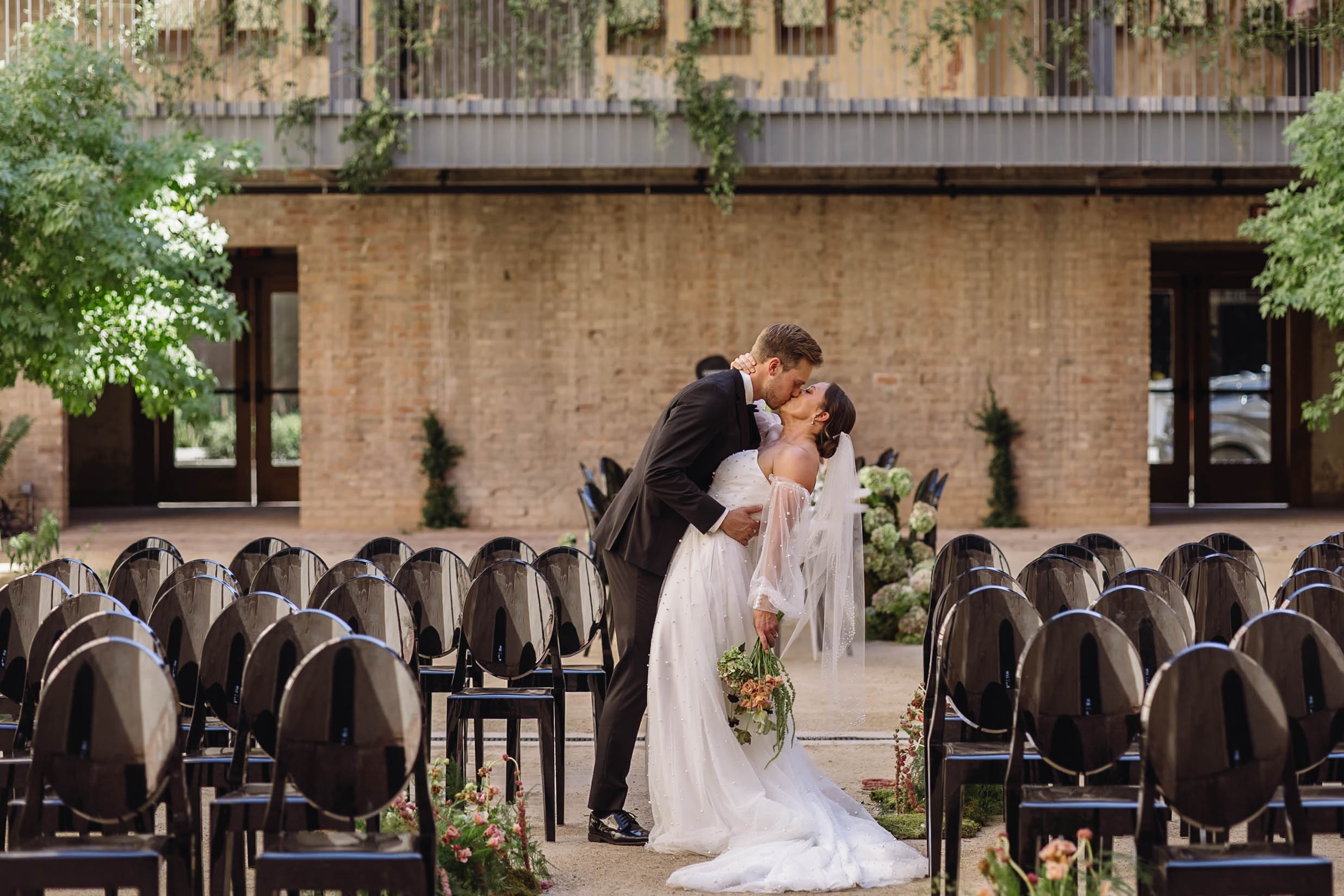 The bride and groom share a private kiss at their wedding.